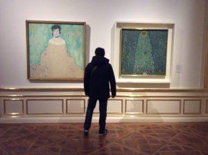 A visitor in front of Gustav Klimt's paintings at the Belvedere: Art with me! e.U., 2019